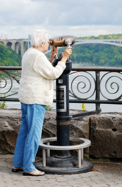 Seniorin blickt auf die Regenbogenbrücke — Stockfoto