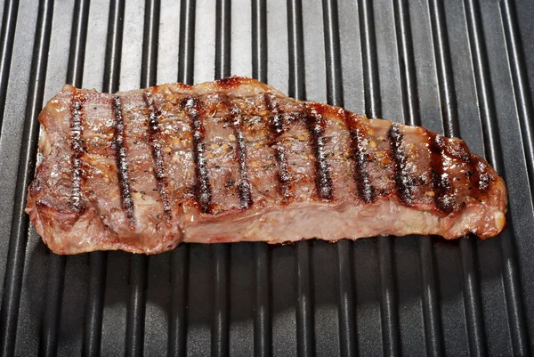 Strip loin steak on a grill — Stock Photo, Image