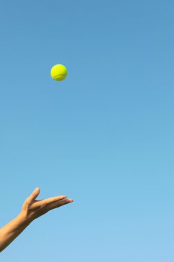 Hand-thrown tennis in the blue sky background clipart