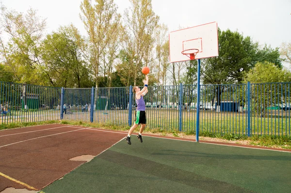 Молоді чоловіки грають у вуличний баскетбол на дитячому майданчику — стокове фото
