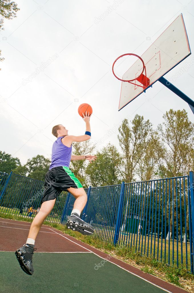 Young men playing street basketball at court playground