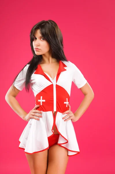 Чувственная брюнетка медсестра позирует на цветном фоне — стоковое фото