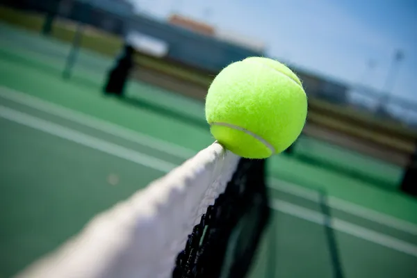 Tennisboll klippning på nätet — Stockfoto