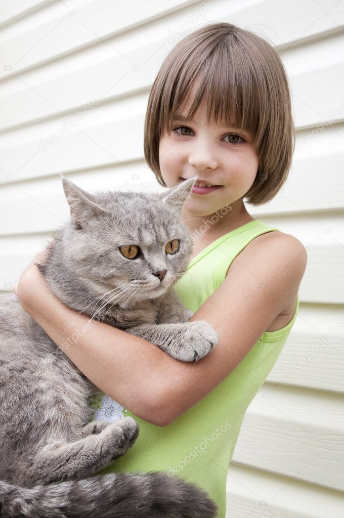 Little girl giving her gray kitten