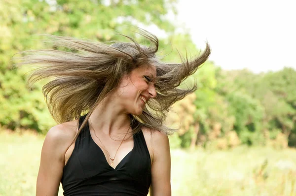 Молодая женщина с ветром дует волосы — стоковое фото