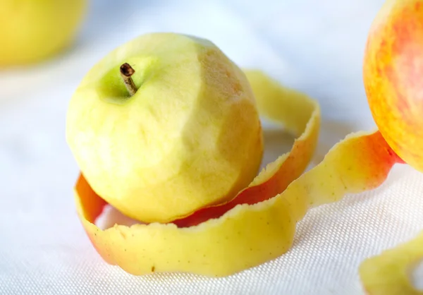 Žluté jablko s oloupané kůže kroucená — Stock fotografie