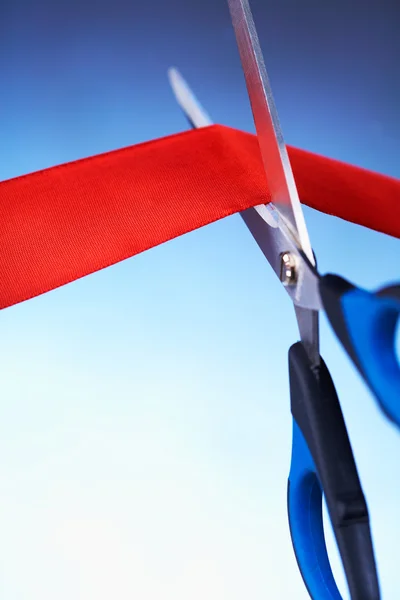 Closeup image of scissors cutting a red ribbon — Stock Photo, Image