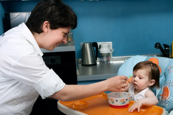 Moeder en baby in de keuken — Stockfoto