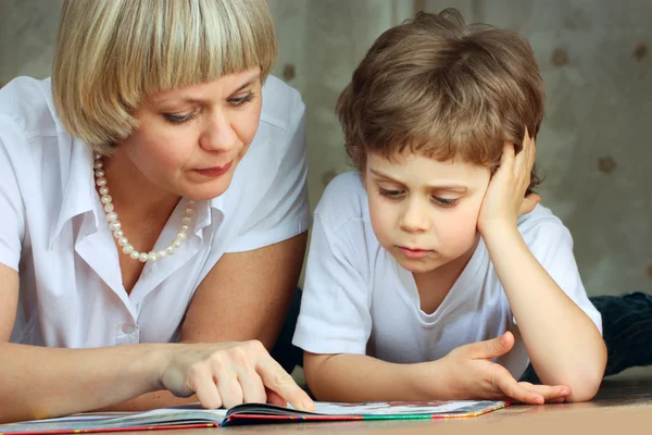 Kvinna och liten pojke läser bok — Stockfoto