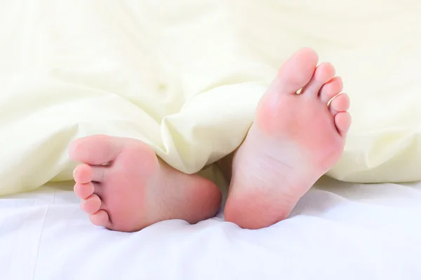 Ноги под одеялом — стоковое фото