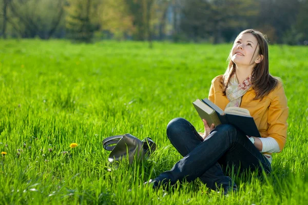 Дівчина з книгою на траві — стокове фото