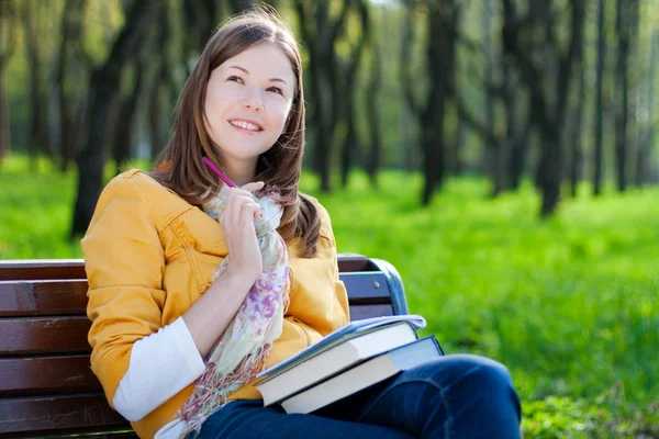 Kobieta z książki w parku — Zdjęcie stockowe