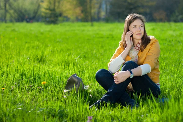 Kobieta na telefon komórkowy w parku — Zdjęcie stockowe