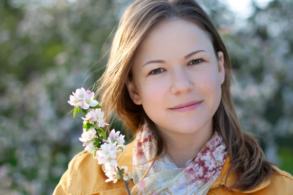 Jonge vrouw in bloeiende park — Stockfoto