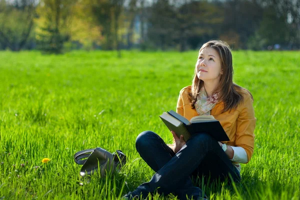 Dziewczyna z książki na trawie — Zdjęcie stockowe