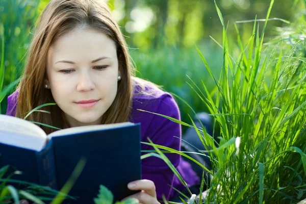 一本书在草地上的女孩 — 图库照片