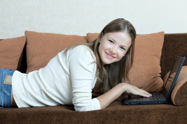 Femme avec ordinateur portable sur le canapé — Photo