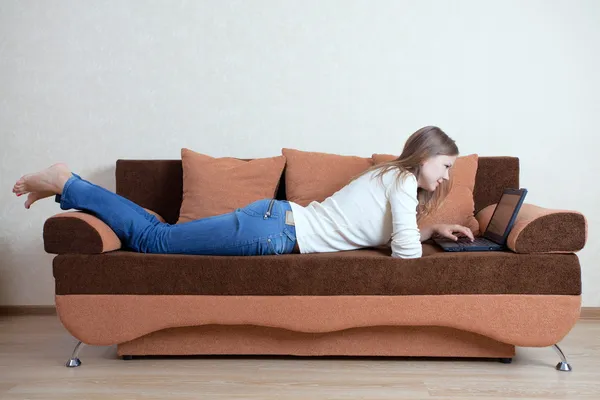 stock image Woman with laptop on the sofa