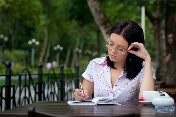 Κορίτσι με το σημειωματάριο στο café — Φωτογραφία Αρχείου