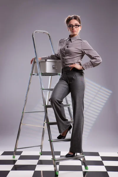 Giovane bella donna su una scala — Foto Stock