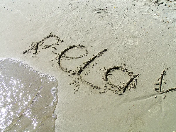 放松一词写在沙子上 — 图库照片