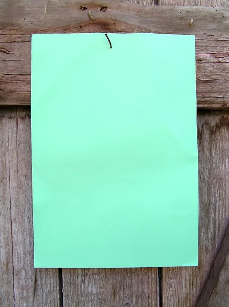 Лист бумаги на деревянной стене . — стоковое фото