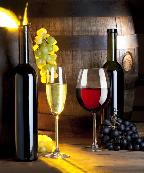 Два бокала вина, бутылки и бочки — стоковое фото