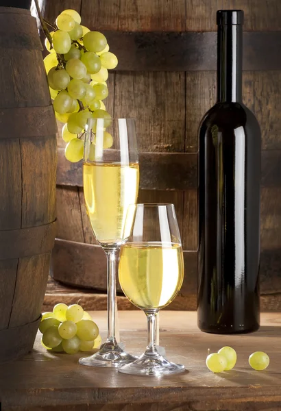 Два бокала вина, бутылки и бочки — стоковое фото