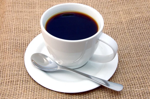 Чашка кофе на мешковине — стоковое фото