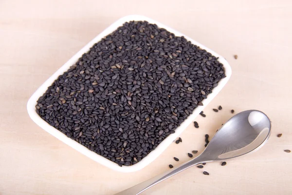 Um prato de sementes de gergelim preto — Fotografia de Stock