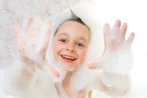 Kind spielt mit Shampoo-Schaum lizenzfreie Stockfotos