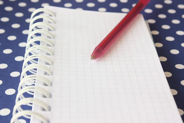 Caderno em espiral com caneta vermelha — Fotografia de Stock