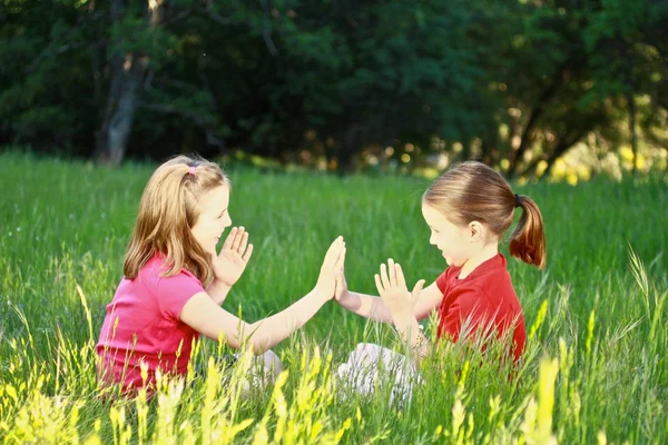 Två små flickor spelar patty-kaka — Stockfoto
