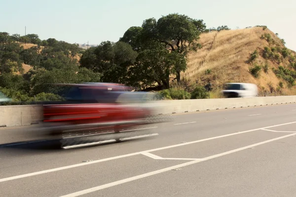 stock image Red vehicles passing by on highway