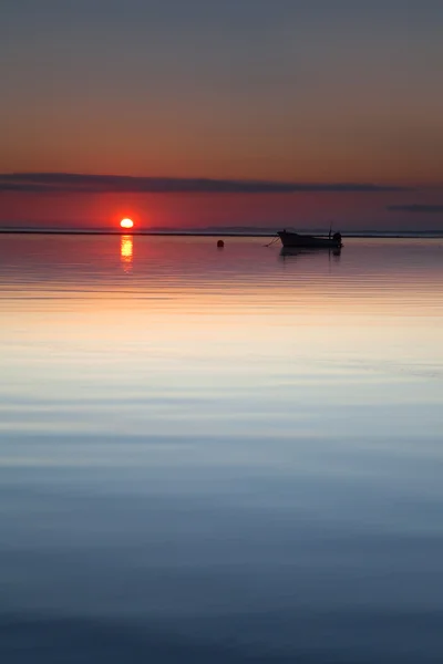 Kleine boot op strand zon opkomst kalme zee te leggen — Stockfoto