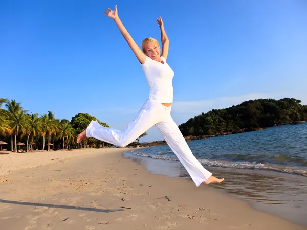 Gelukkige vrouw is springen in het strand — Stockfoto