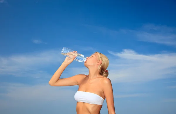 Mujer bebiendo agua en la playa —  Fotos de Stock