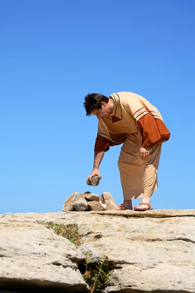 Homem pegando pedra ou fazendo pilha de rocha . — Fotografia de Stock