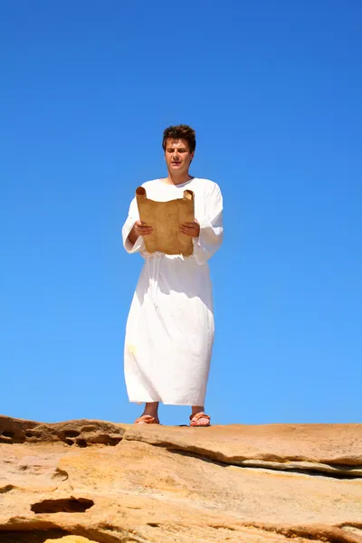 Mann liest Schriftrolle in felsiger Wüste — Stockfoto