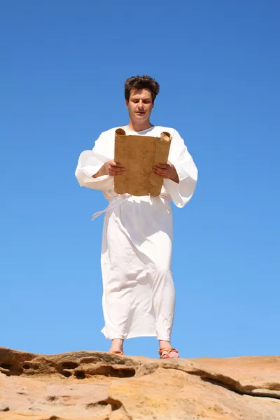 Man in traditional robe reading scroll — Stock Photo, Image