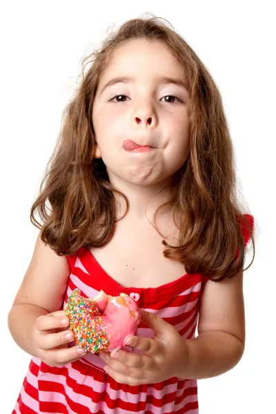 Girl eating doughnut licking lips — Stock Photo, Image