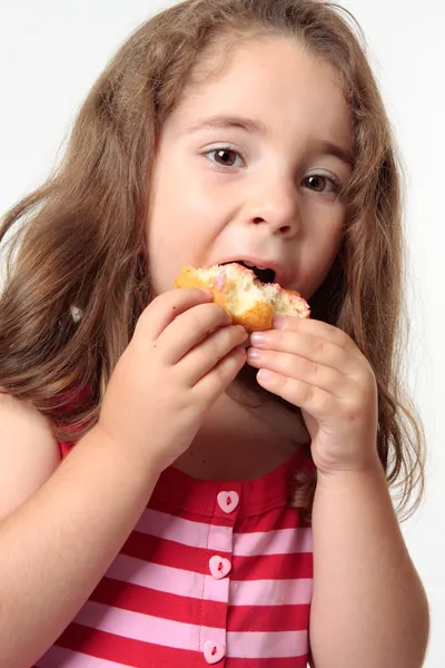 Barnet äta skräpmat donut. — Stockfoto
