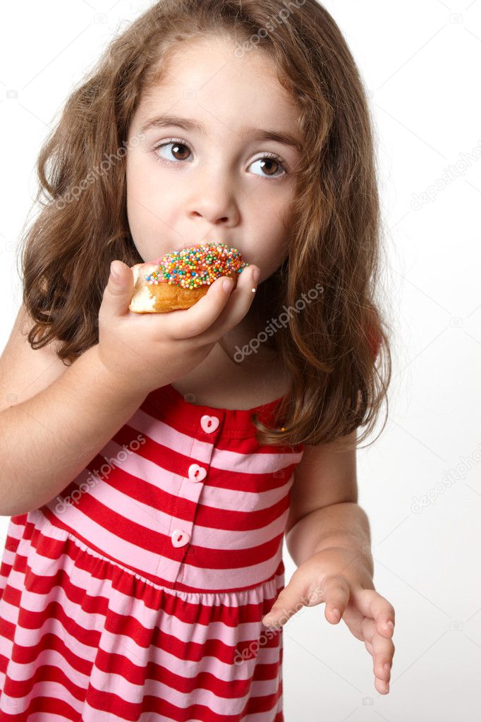 Pretty little girl eating a doughnut