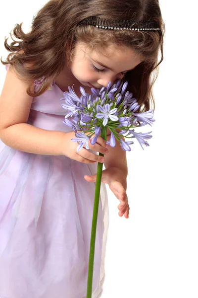Menina cheirando uma flor bonita — Fotografia de Stock
