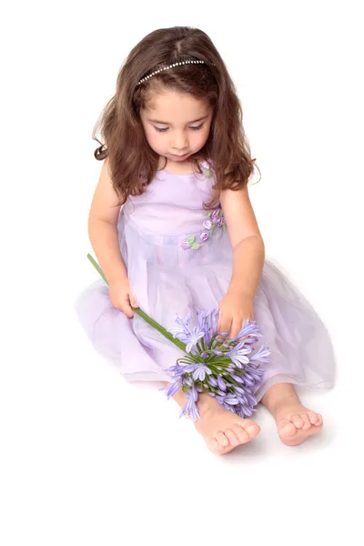 Malá dívka si hraje s květinou — Stock fotografie
