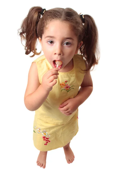 Güzel kız bir lolipop şeker yemek — Stok fotoğraf