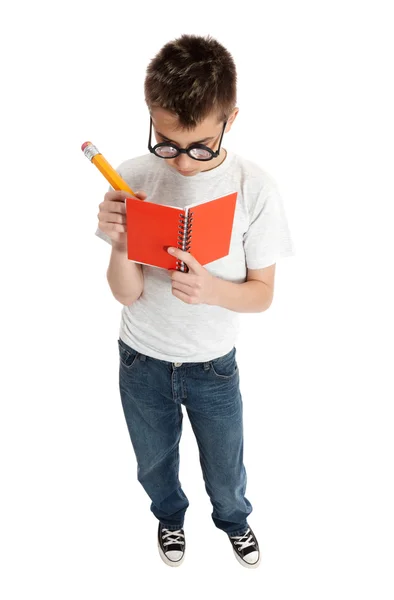 Мальчик пишет в блокноте — стоковое фото