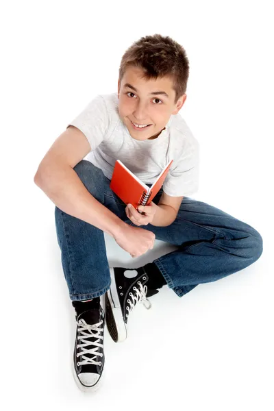 Pré adolescente menino sentado com um livro — Fotografia de Stock