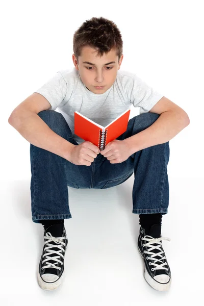 Мальчик, читающий блокнот — стоковое фото