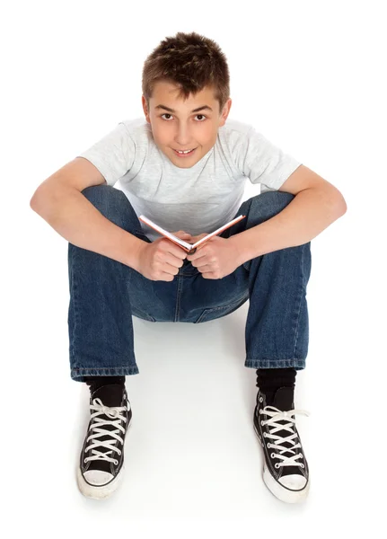 Мальчик в джинсах сидит на полу — стоковое фото